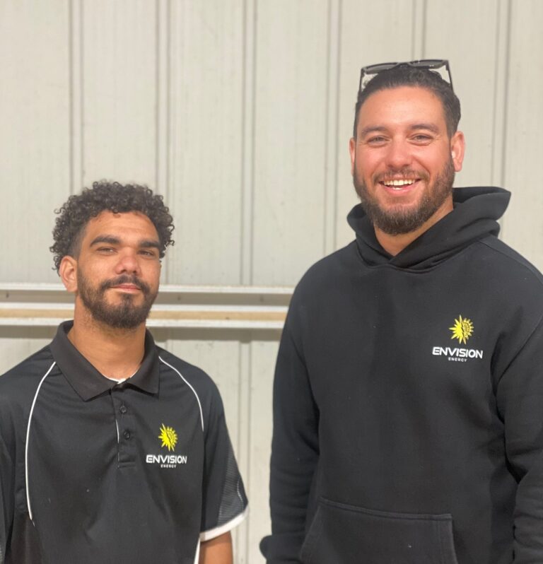 Two Australian indigenous men with Envison Energy company shirts on.